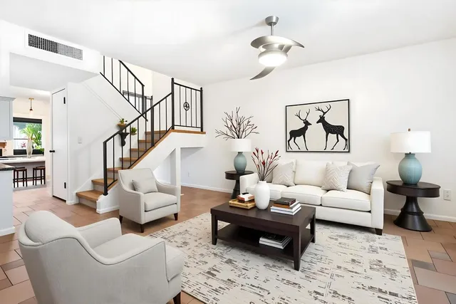 a living room with furniture ceiling fan and a rug