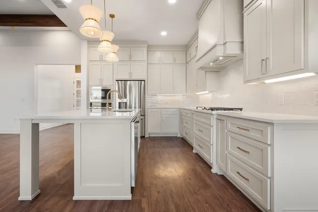 a kitchen with white cabinets and stainless steel appliances