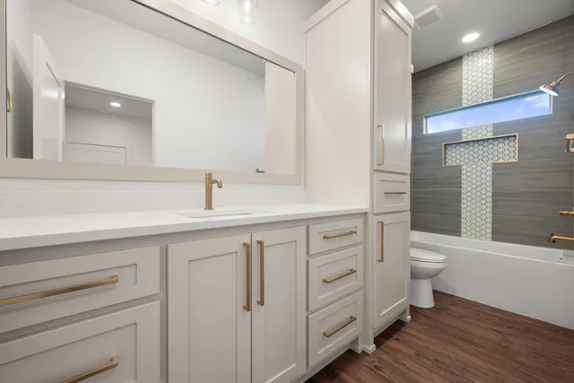 a bathroom with a double vanity sink toilet and a tub