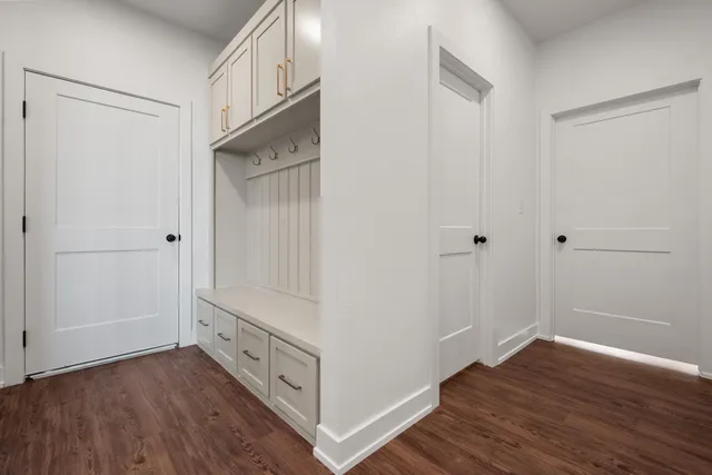 a view of an empty room with wooden floor and closet