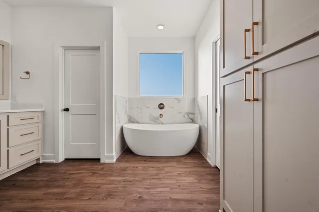 a view of an empty room with wooden floor and closet