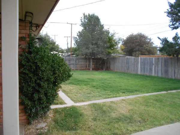 a view of backyard with wooden fence