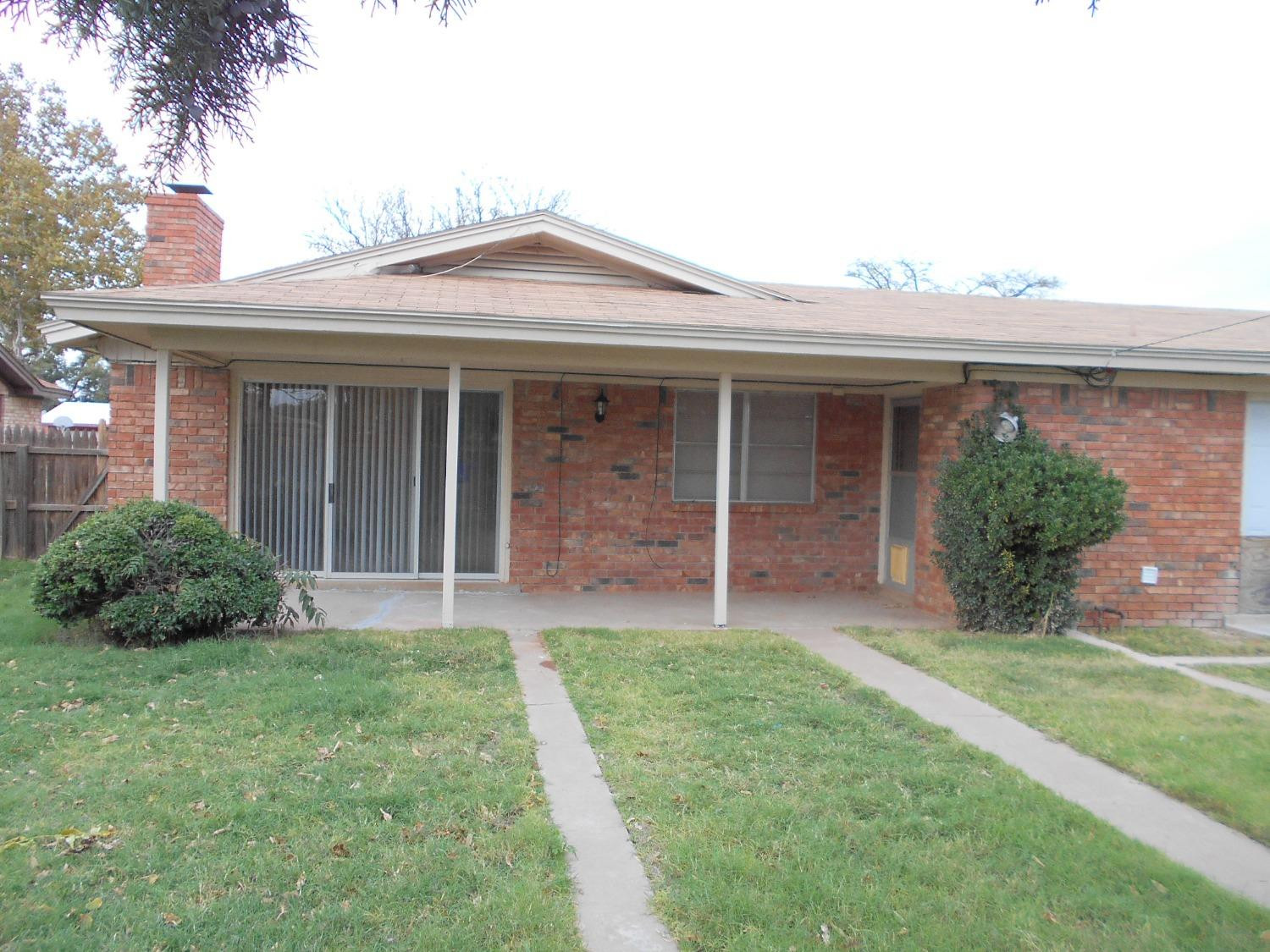 5401 14th Street Lubbock, TX 79416 - Photo 17 of 17 a view of brick house with a yard potted plants and a table