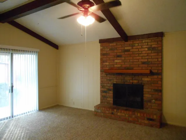 a view of empty room with fireplace and fan