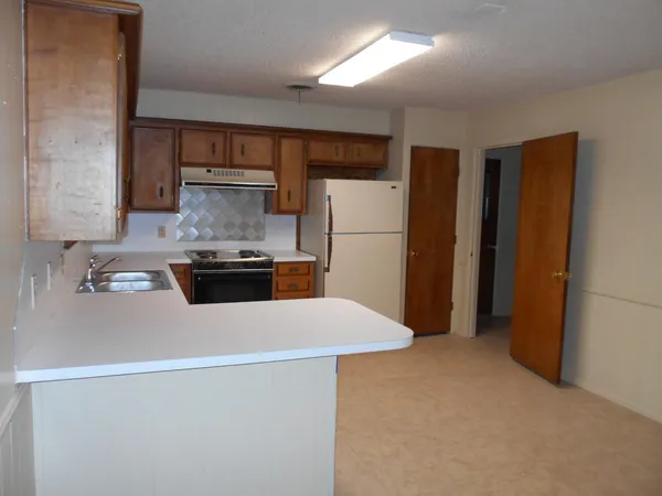 a kitchen with refrigerator and white cabinets