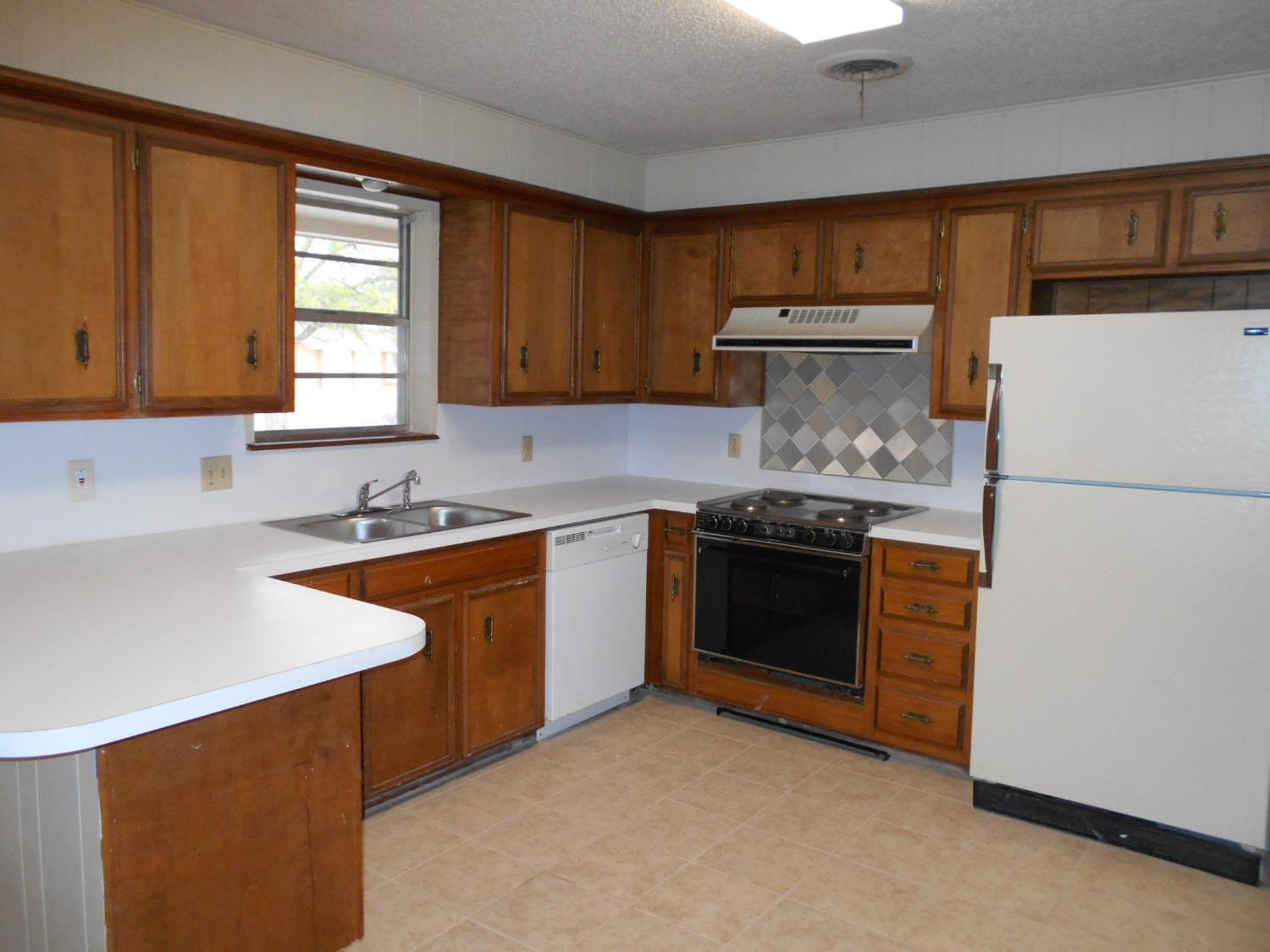 5401 14th Street Lubbock, TX 79416 - Photo 7 of 17 a kitchen with a stove a sink and a refrigerator