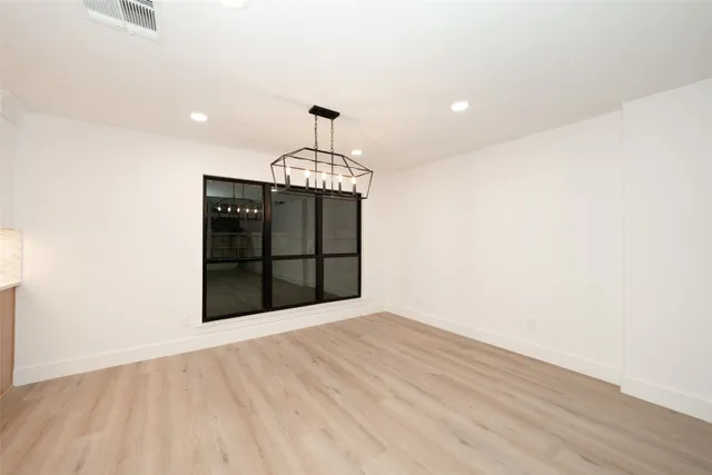 a view of a room with a wooden floor and chandelier