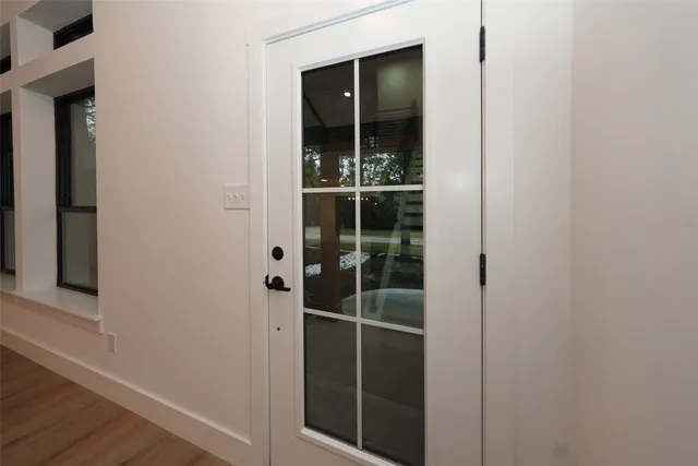 a view of a hallway with wooden floor and staircase