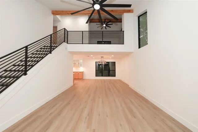 a large white kitchen with a large counter top a sink a refrigerator and stainless steel appliances