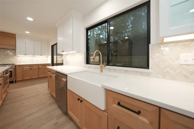 a kitchen with stainless steel appliances kitchen island sink refrigerator and cabinets