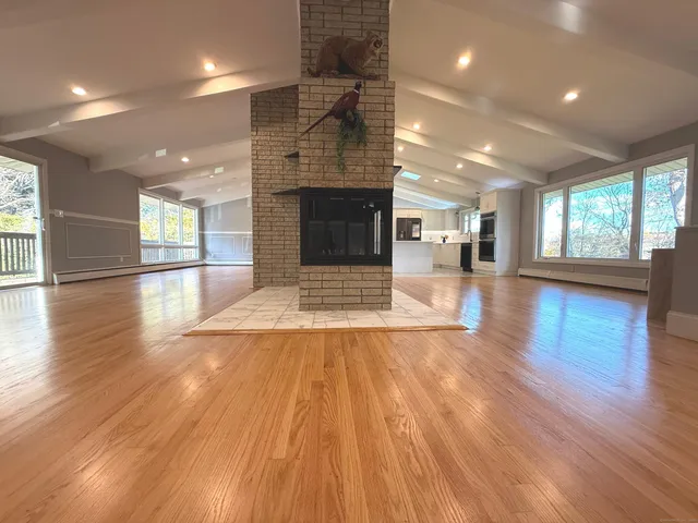 an empty room with wooden floor and fireplace
