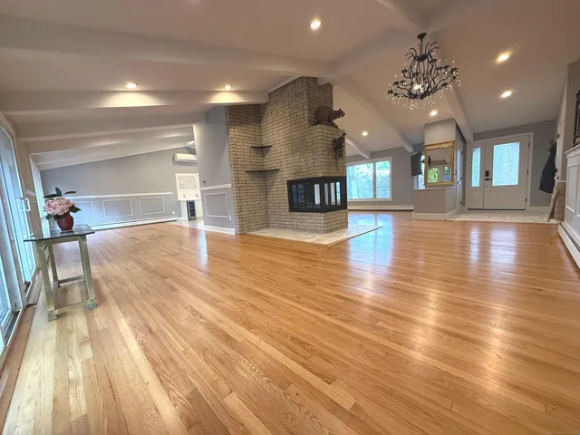 a view of a room with lots of wooden furniture and a large window