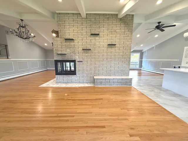a view of empty room with kitchen and window