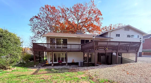 a view of a chairs and tables in the patio and a fountain in front of house