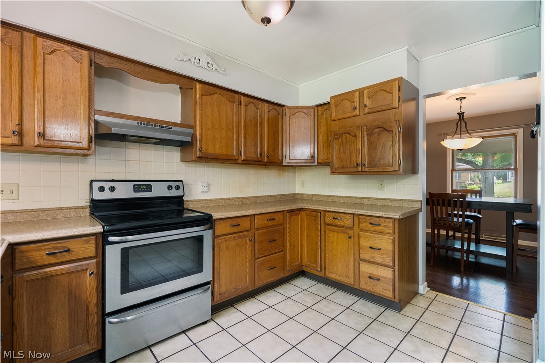 542 Garnette Road Akron, OH 44313 - Photo 6 of 24 Kitchen featuring wood-finish cabinetry, tile flooring, and laminate countertops