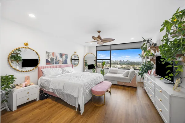 a bedroom with a bed mirror and a potted plant