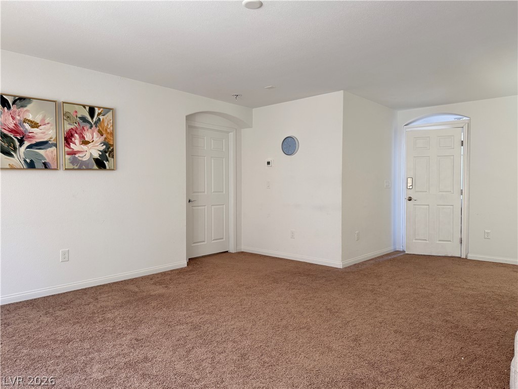 7777 South Westwind Road Las Vegas, NV 89139 - Photo 7 of 46 A spacious common area offers plush carpeting and classic arched doorways.
