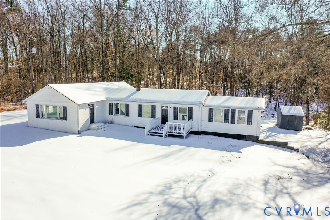 a front view of a house with a yard outdoor seating and covered with trees