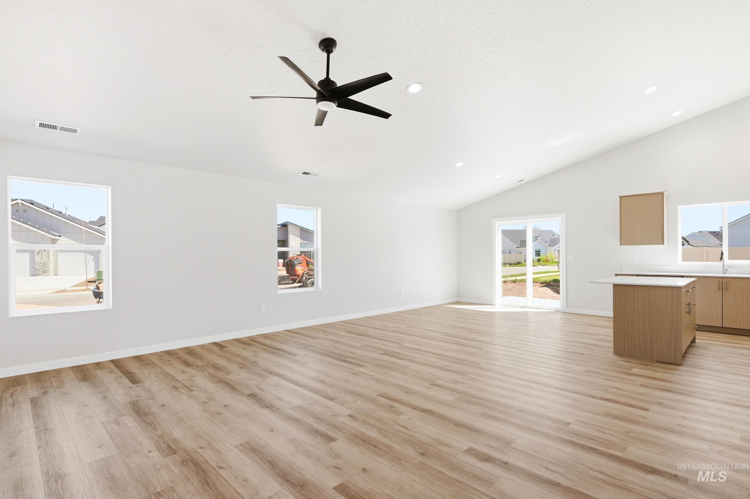 12817 Decatur Street Nampa, ID 83651 - Photo 9 of 19 Spacious interior featuring vaulted ceilings, light wood-finish flooring, a modern black ceiling fan, and recessed lighting