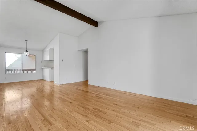 a view of a kitchen with wooden floor and a refrigerator