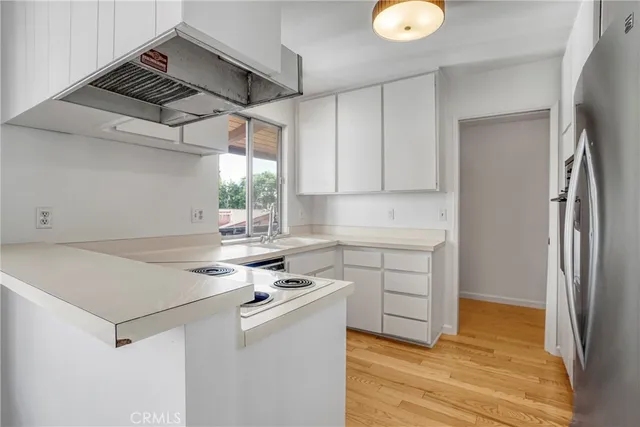 a metallic refrigerator freezer sitting in a kitchen