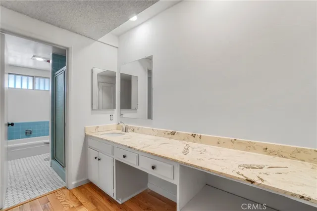 a bathroom with a granite countertop tub sink and mirror