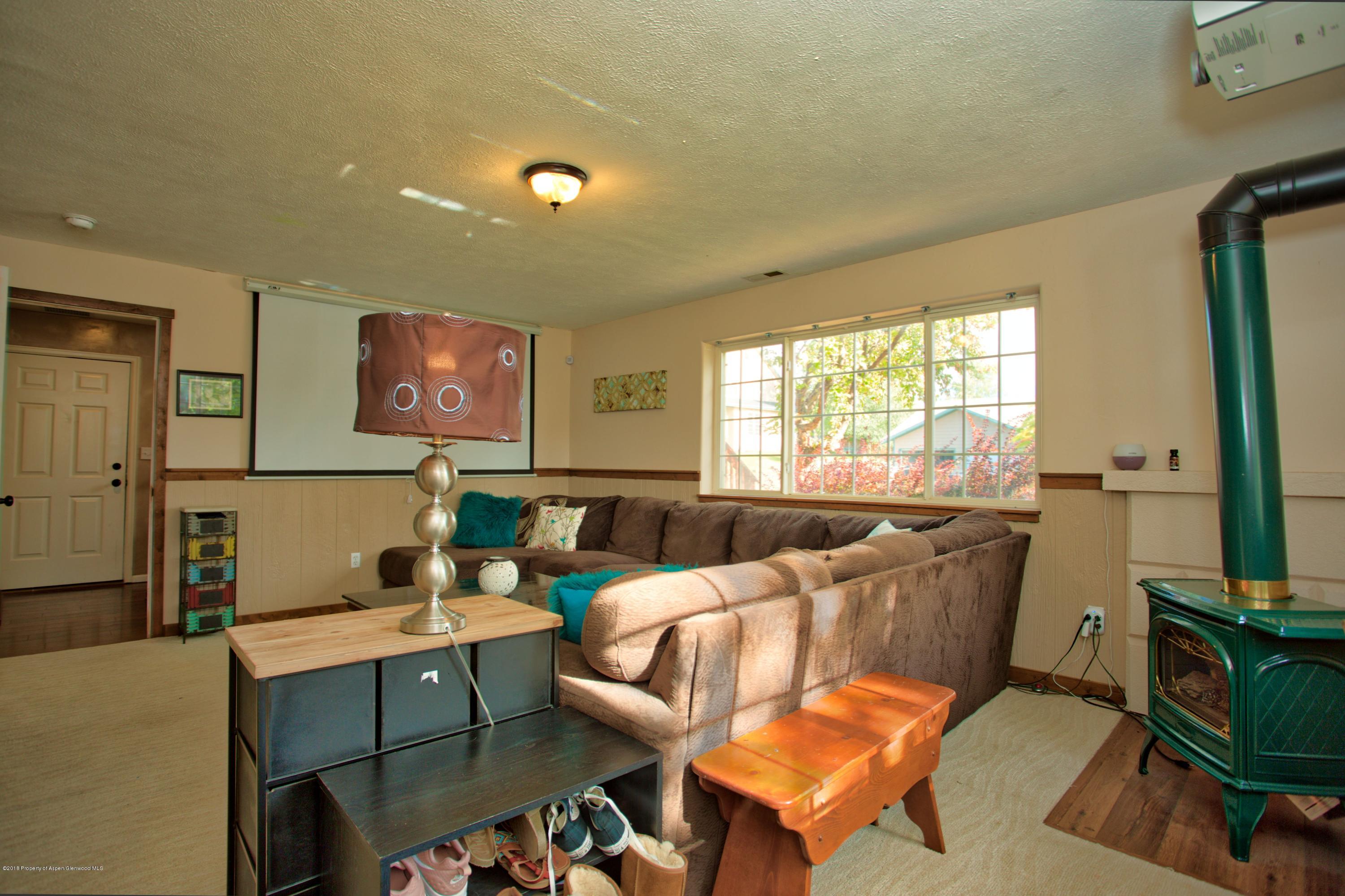 841 Hickory Drive Rifle, CO 81650 - Photo 16 of 20 a living room with furniture a flat screen tv and a large window