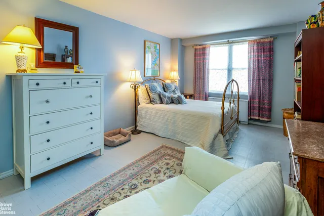 a kitchen with stainless steel appliances kitchen island granite countertop a refrigerator a stove and a wooden floor