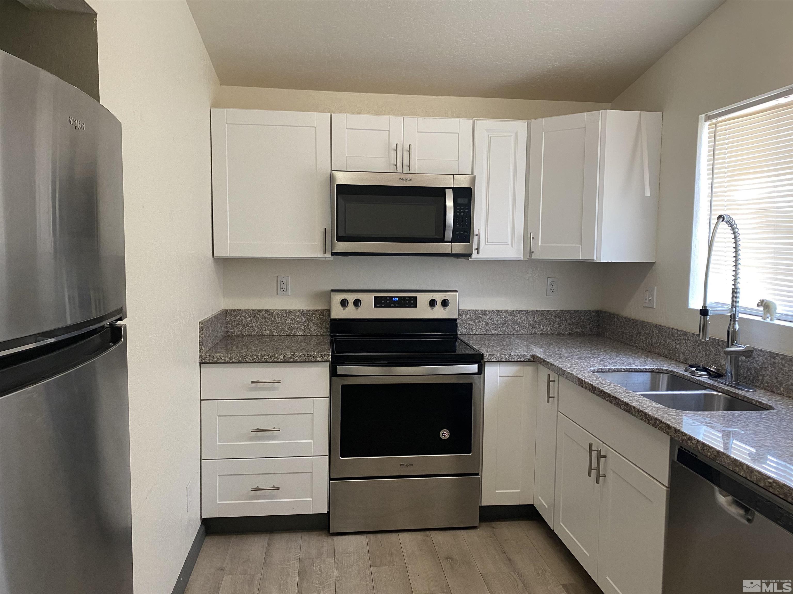 656 Spokane Street Reno, NV 89512 - Photo 2 of 31 a kitchen with white cabinets and stainless steel appliances