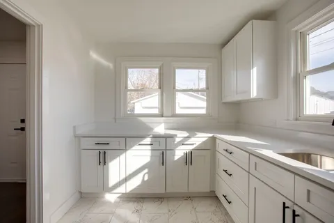 a kitchen with cabinets appliances a sink and a window