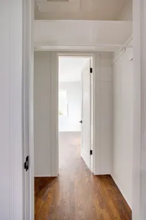 a view of a hallway with wooden floor
