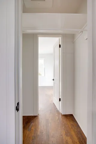 a view of a hallway with wooden floor