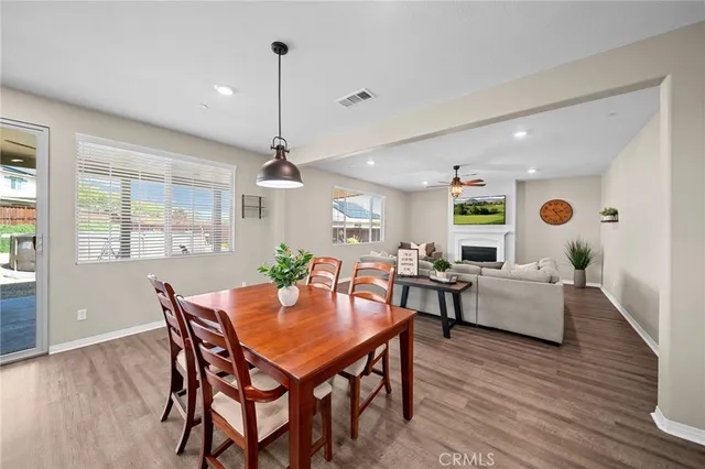 a view of a kitchen with a dining table chairs wooden floor and stainless steel appliances