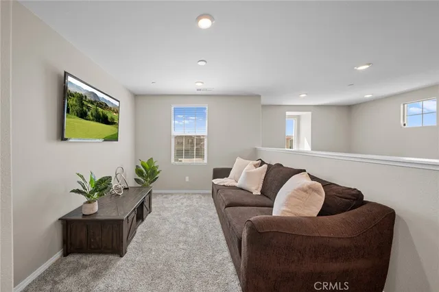 a spacious bedroom with a bed and a view of kitchen