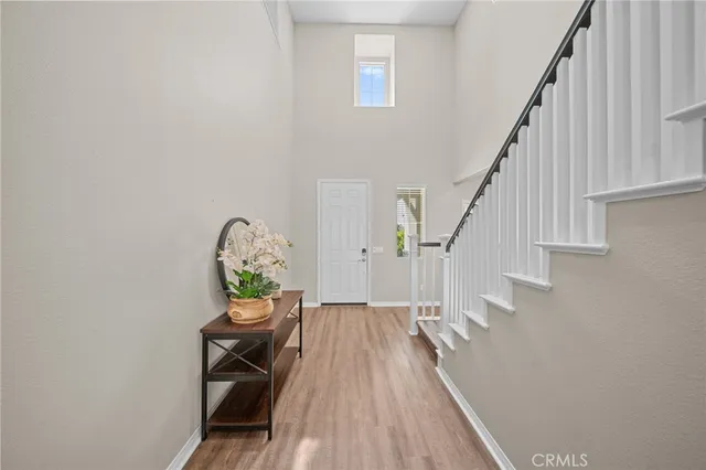 a view of a hallway with wooden floor and a dining room