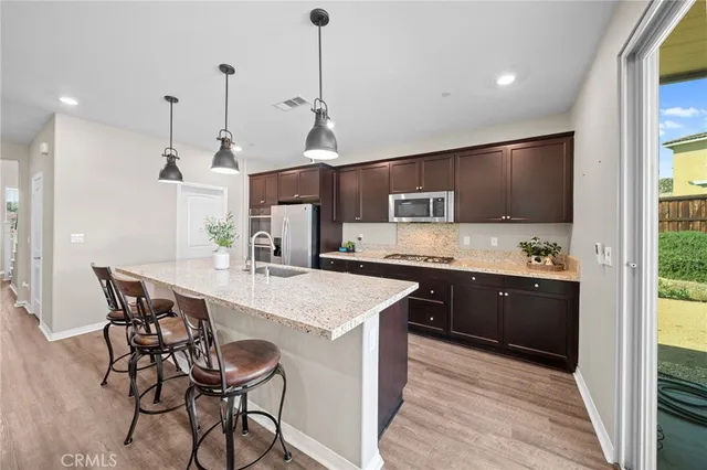 a kitchen with stainless steel appliances granite countertop a kitchen island hardwood floor sink and stove