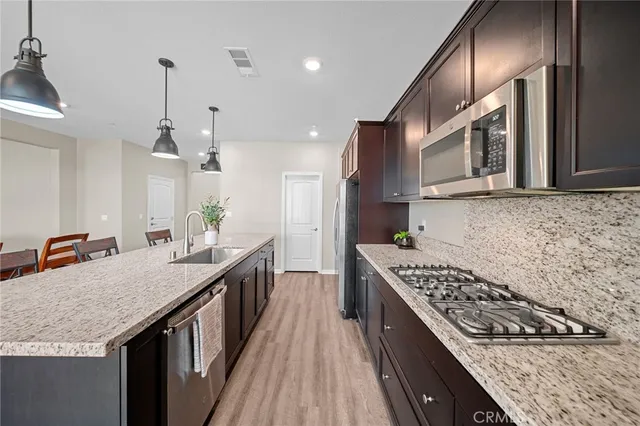 a kitchen with stainless steel appliances granite countertop a sink stove and cabinets