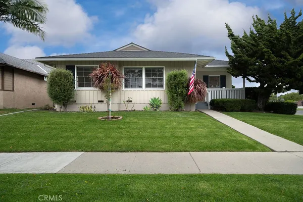 a front view of a house with a garden and yard