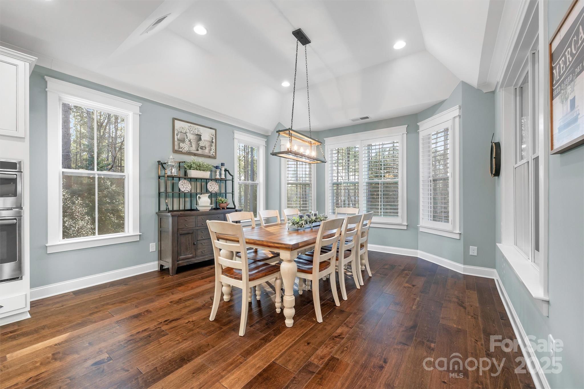 4221 Persimmon Road Lancaster, SC 29720 - Photo 13 of 48 a dining room with wooden floor a chandelier a wooden table and chairs