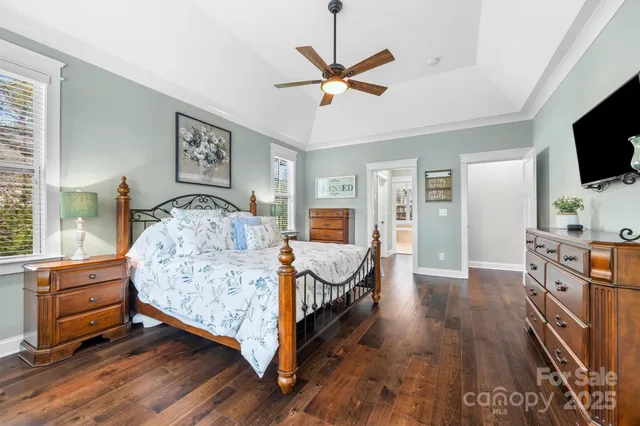 a bedroom with a bed a flat screen tv and dresser