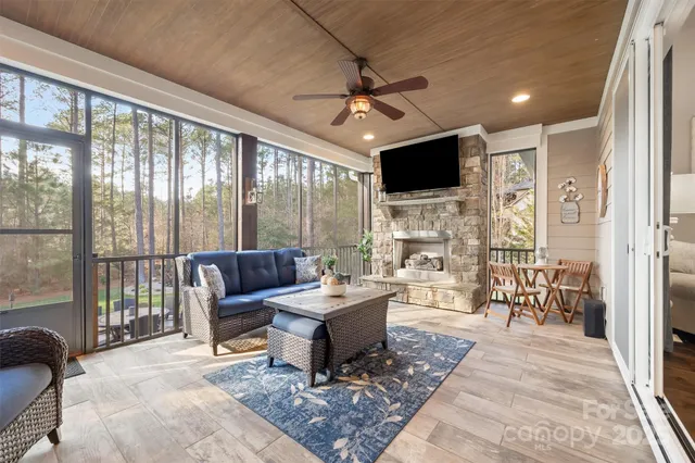 a living room with furniture a flat screen tv and a floor to ceiling window