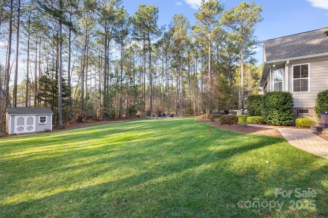 a view of a house with a big yard and palm trees