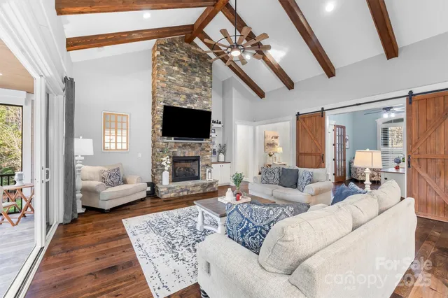 a living room with furniture a fireplace and a flat screen tv