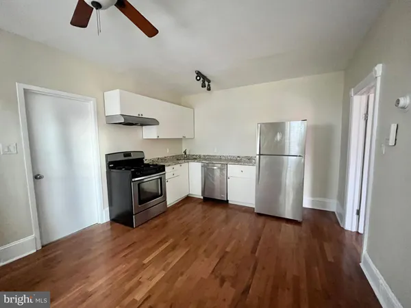 a kitchen with white cabinets and stainless steel appliances