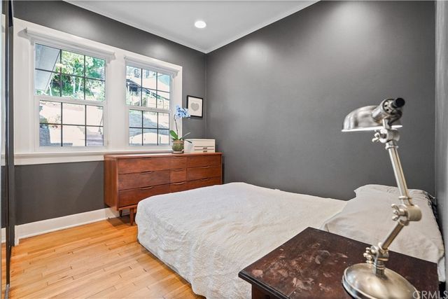 a bedroom with a bed and a dresser next to a window