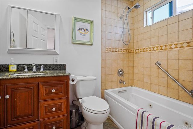 a bathroom with a granite countertop toilet a sink and bathtub
