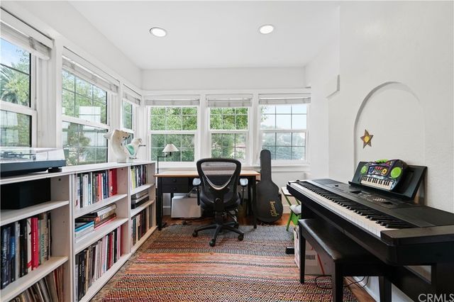 a view of a workspace with furniture and a book shelf
