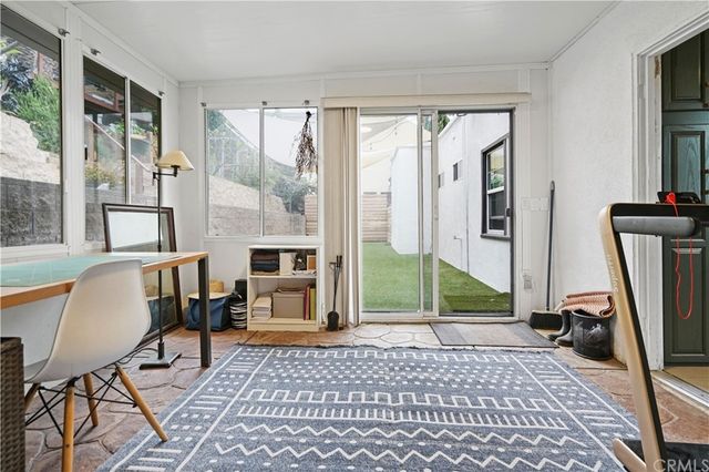 a living room with furniture a flat screen tv and a floor to ceiling window