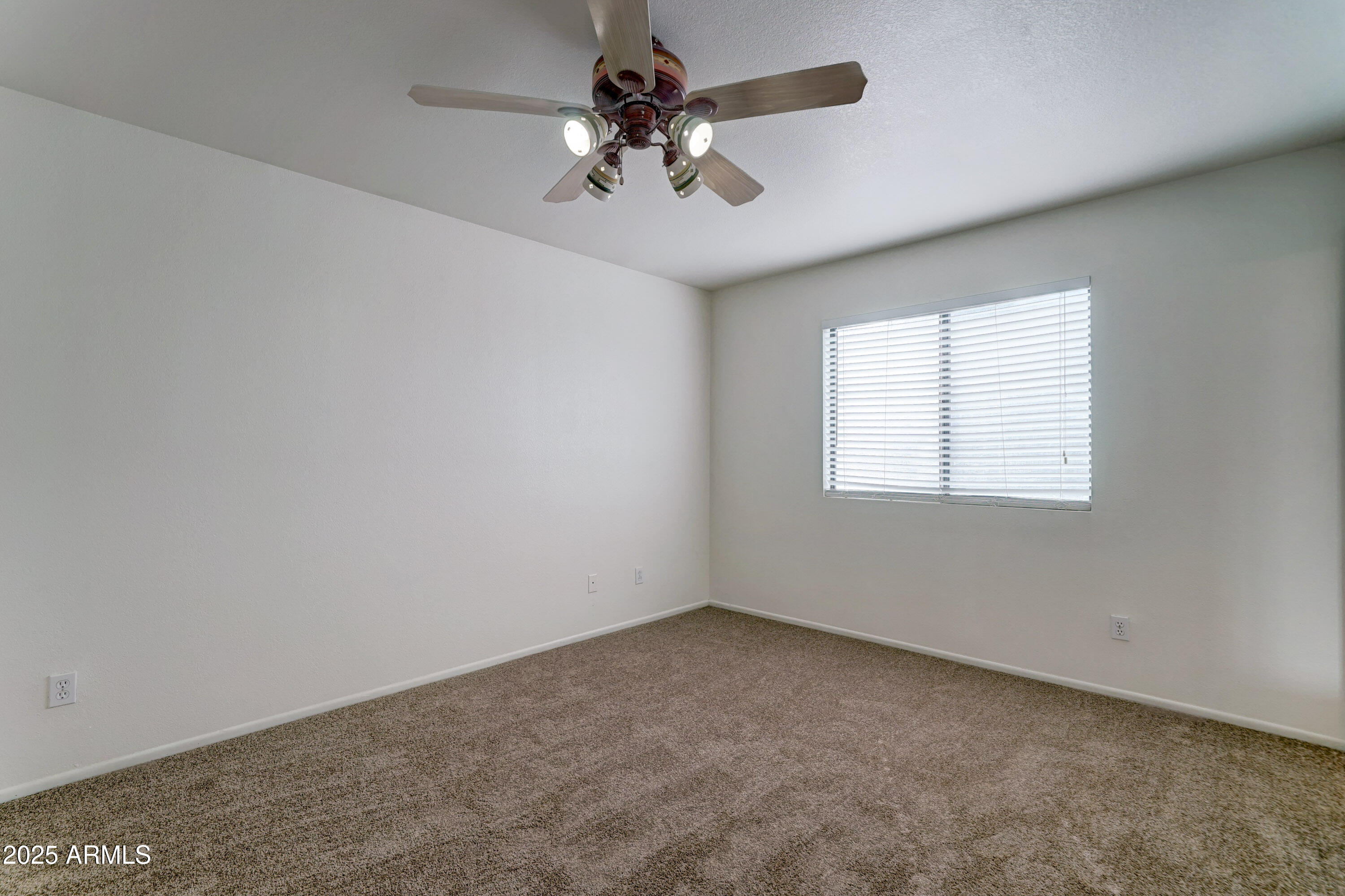 Undisclosed Address Phoenix, AZ 85024 - Photo 16 of 32 an empty room with a chandelier fan and windows