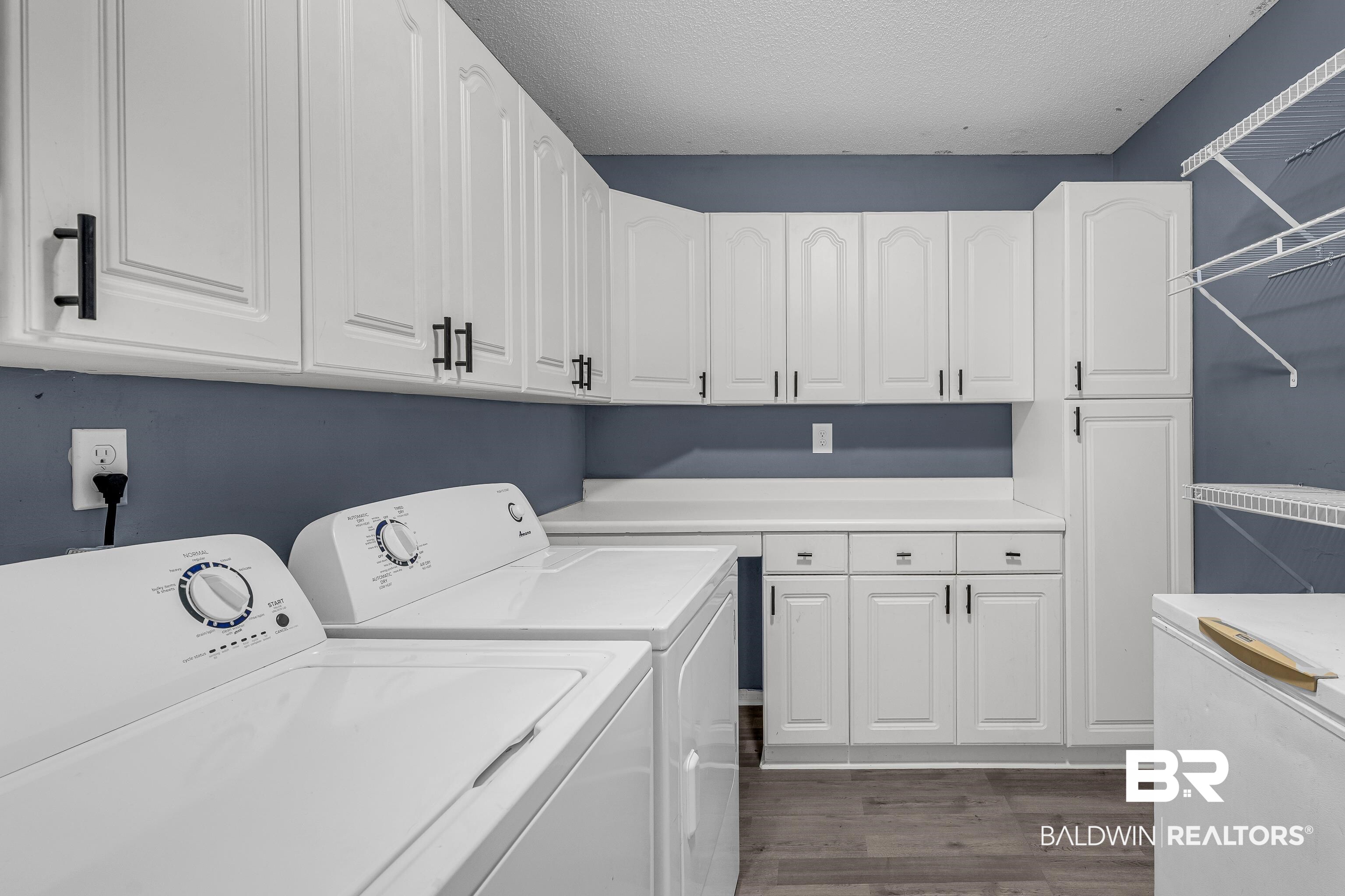 6135 Oak Cliff Drive Eight Mile, AL 36613 - Photo 15 of 30 Washroom featuring dark wood-style floors, a textured ceiling, washing machine and dryer, and cabinet space